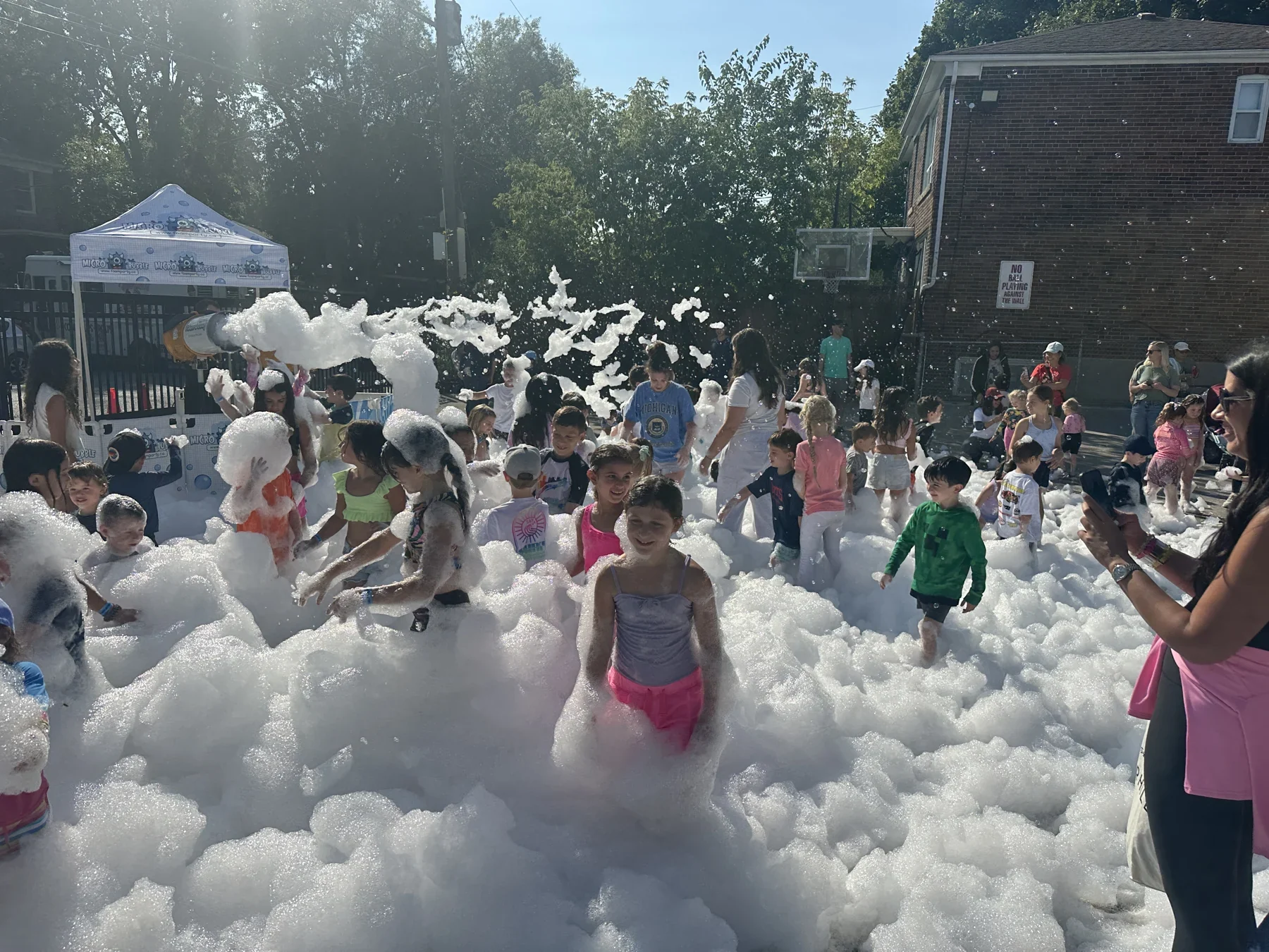 A joyful crowd surrounded by mountains of foam at a Presswood event